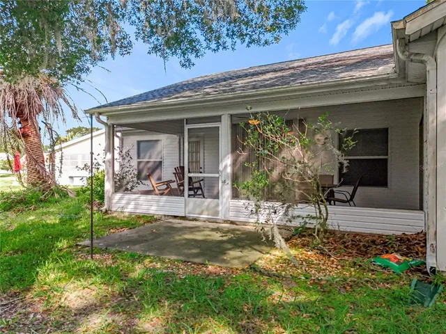 an aerial view of residential houses with outdoor space and trees