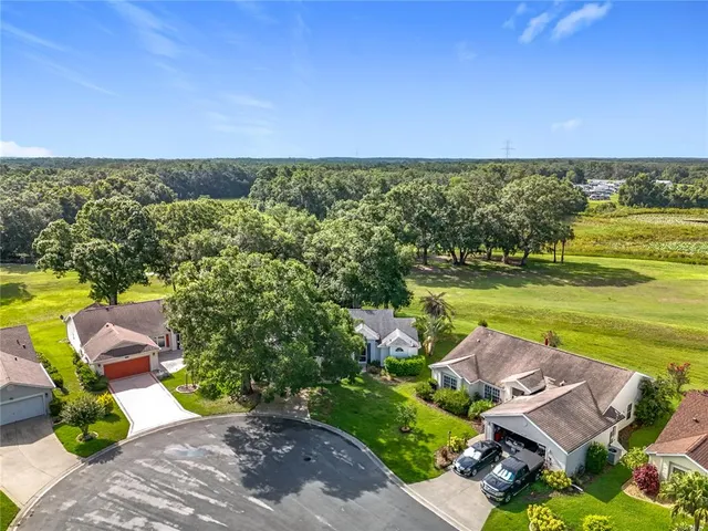 a living room with furniture and a dining table with wooden floor