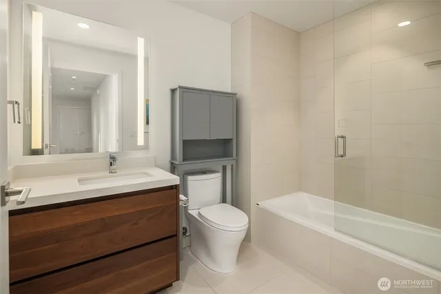 a bathroom with a glass shower door and a sink