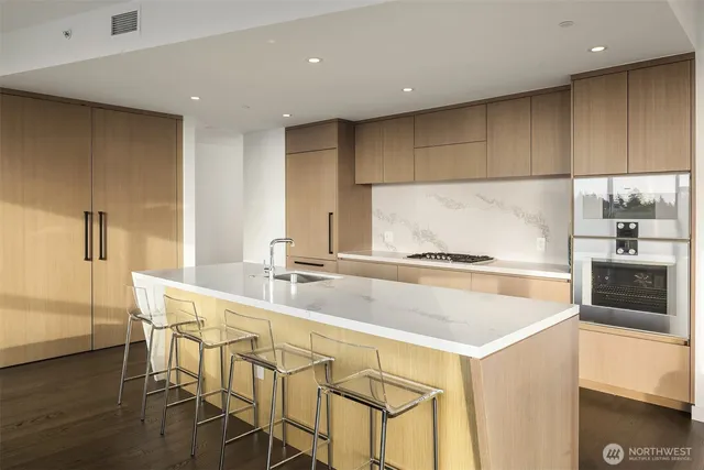 a kitchen with a table chairs cabinets and wooden floor