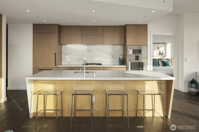 a view of a kitchen with kitchen island granite countertop a table and chairs in it
