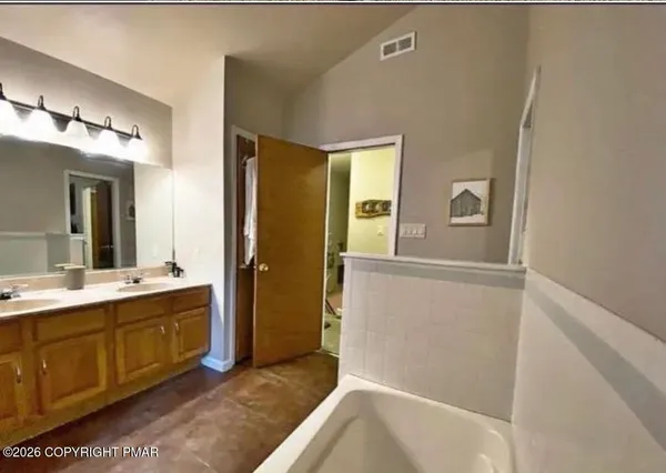 a bathroom with a tub sink and mirror