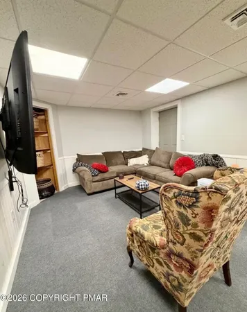 a living room with furniture gym equipment and a mirror