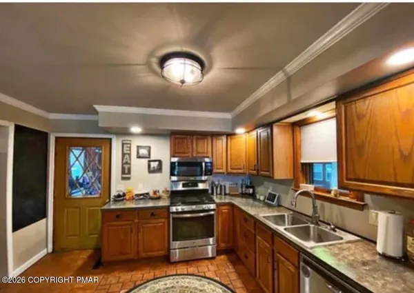 a kitchen with stainless steel appliances granite countertop a stove sink and microwave