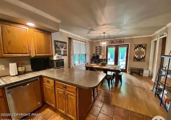 a kitchen with stainless steel appliances granite countertop a stove a sink a dining table and chairs with wooden floor