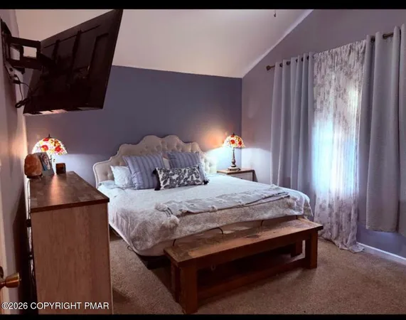 a bed sitting in a bedroom next to a window