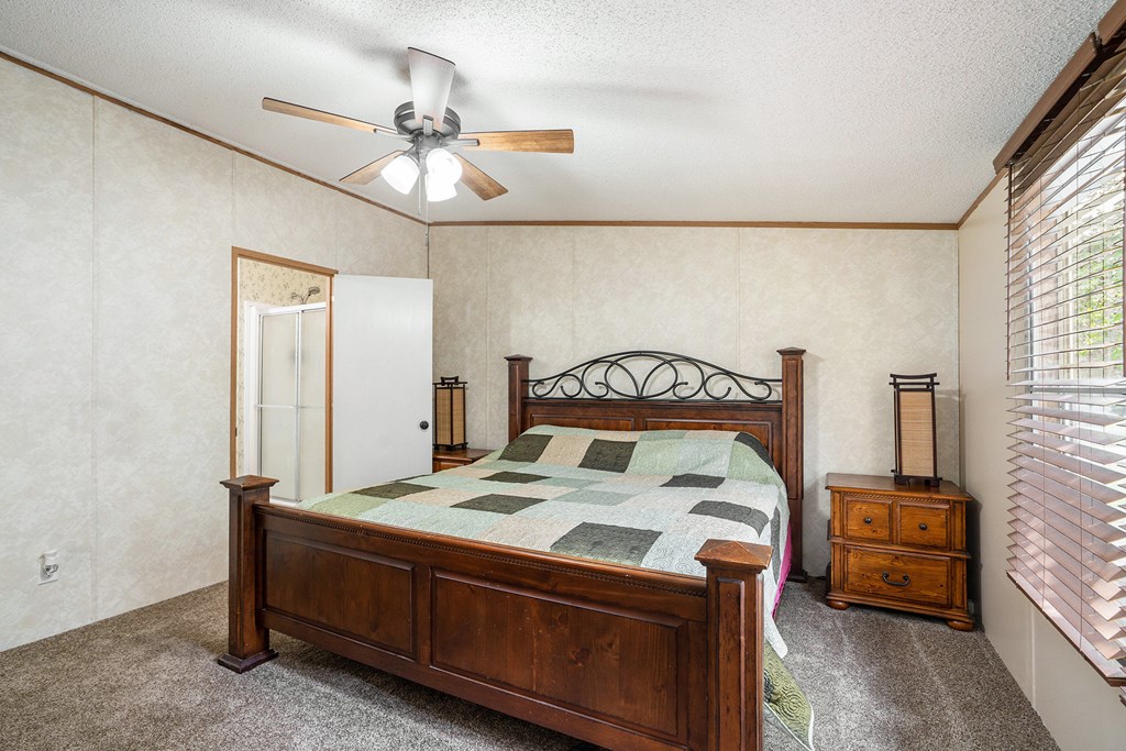 359 Norton Bridge Road Chatsworth, GA 30705 - Photo 13 of 28 a bed sitting in a bedroom next to a window with a chandelier