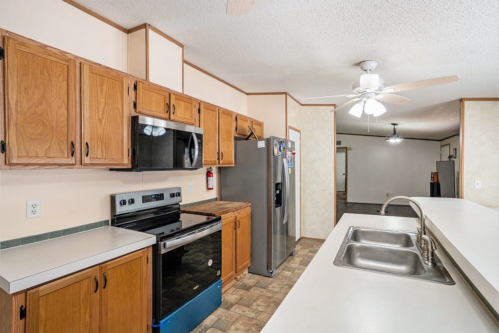 359 Norton Bridge Road Chatsworth, GA 30705 - Photo 8 of 28 a kitchen with stainless steel appliances a stove microwave and a refrigerator