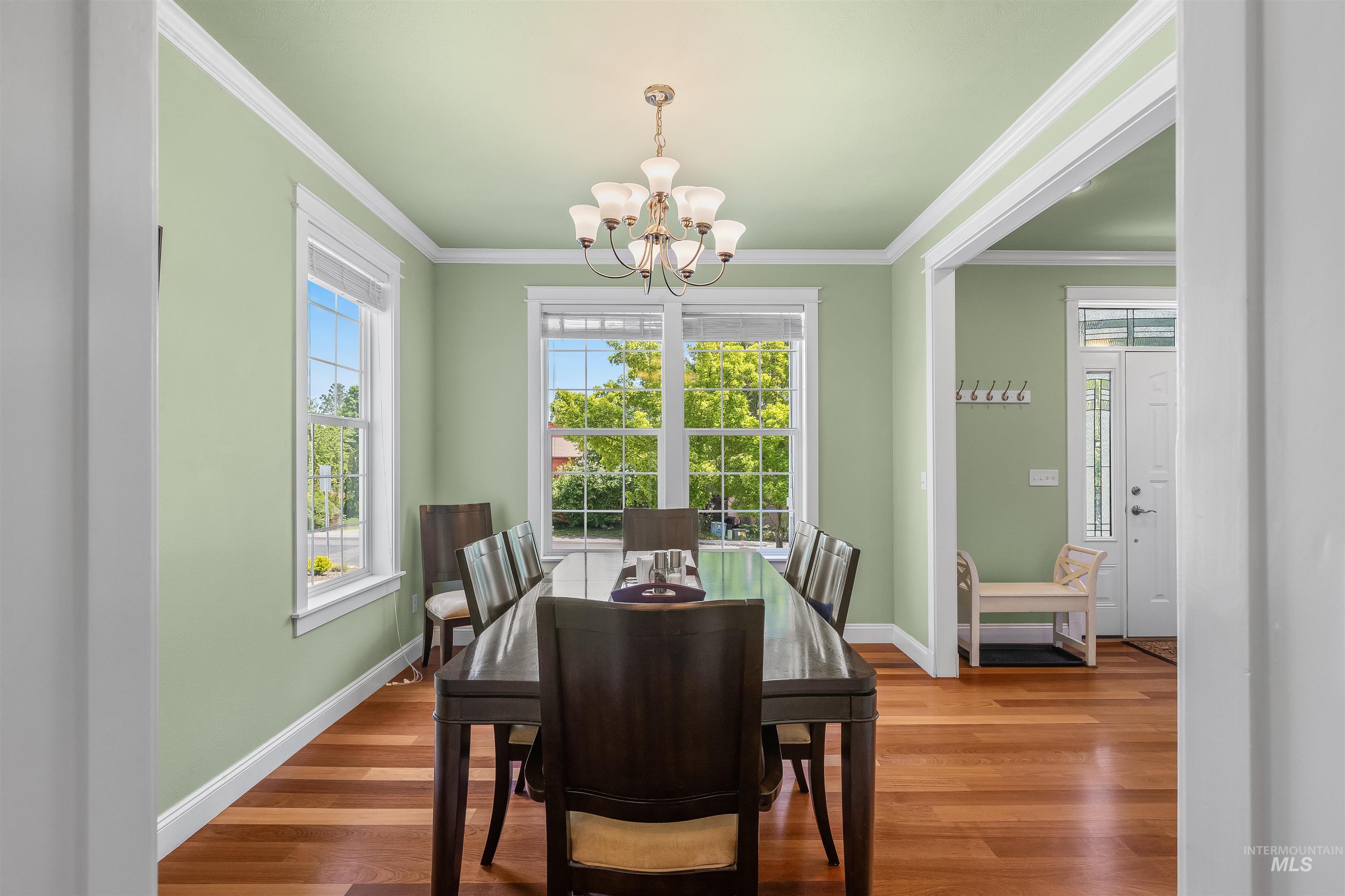1617 Pine Cone Road Moscow, ID 83843 - Photo 8 of 44 Dining area featuring wood-finish flooring, white crown molding, and two large windows