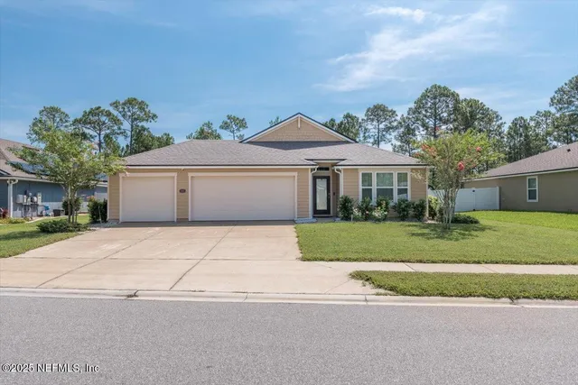 a front view of a house with a yard and a garage