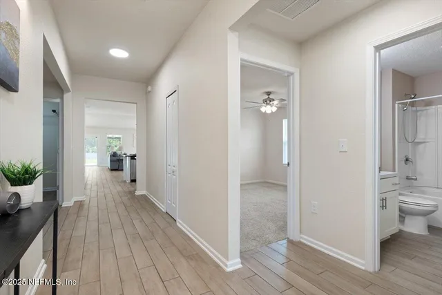 an empty room with a window and a fan