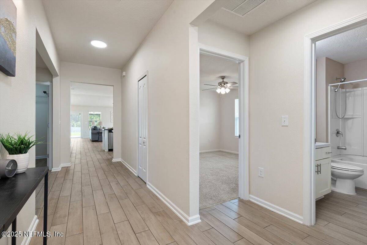 88 North Hamilton Springs Road St. Augustine, FL 32084 - Photo 12 of 73 a view of a hallway with wooden floor and a bathroom