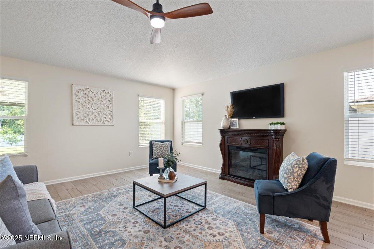 88 North Hamilton Springs Road St. Augustine, FL 32084 - Photo 25 of 73 a living room with furniture a flat screen tv and a fireplace