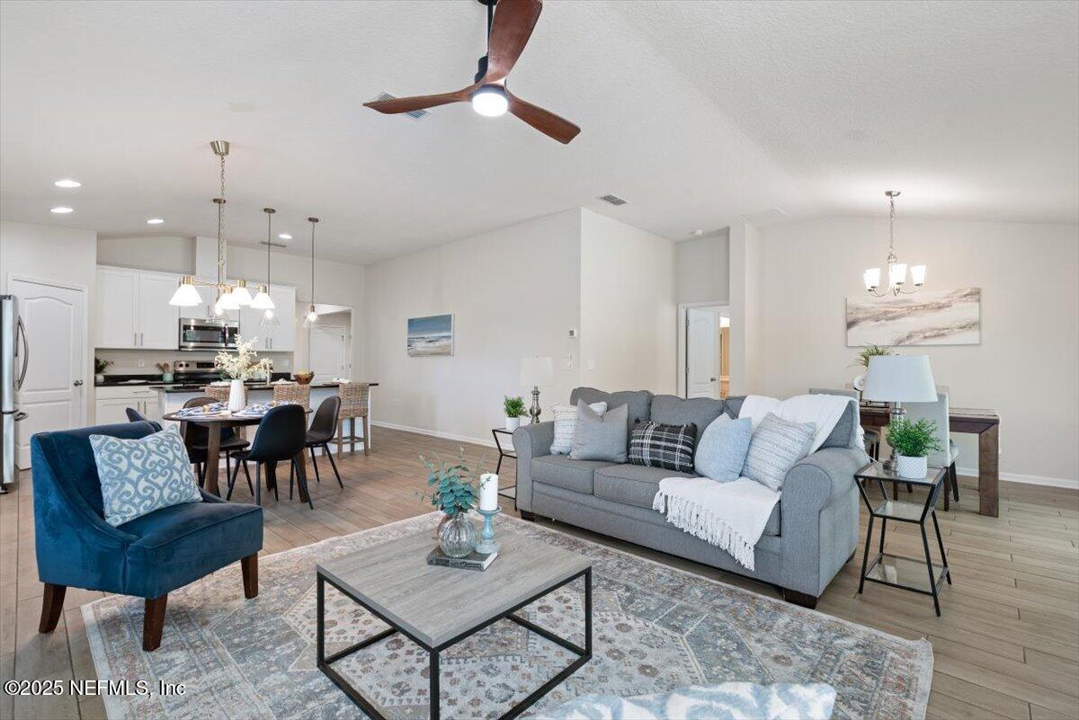 88 North Hamilton Springs Road St. Augustine, FL 32084 - Photo 26 of 73 a living room with furniture kitchen view and a chandelier