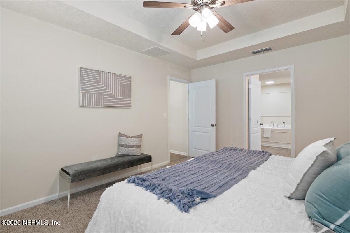 88 North Hamilton Springs Road St. Augustine, FL 32084 - Photo 32 of 73 a bedroom with a bed and a chandelier