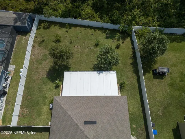an aerial view of a house with a yard and lake view
