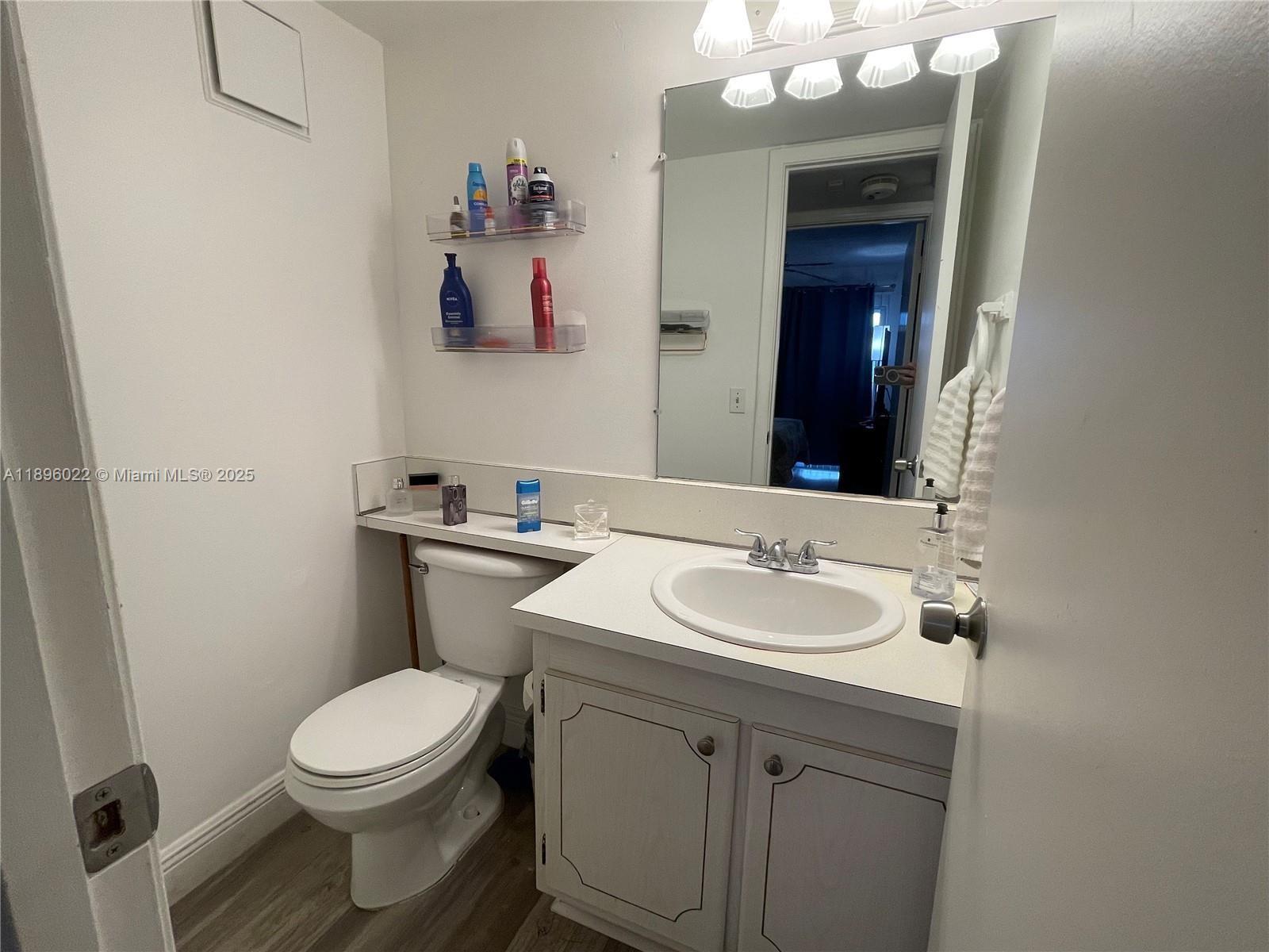 279 Markham M, Unit M Deerfield Beach, FL 33442 - Photo 13 of 15 a bathroom with a sink vanity mirror and toilet