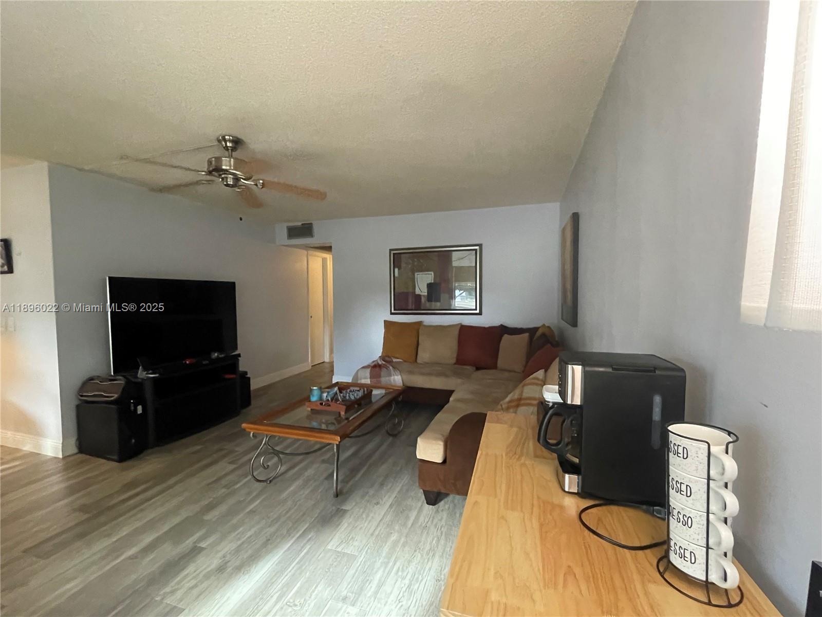 279 Markham M, Unit M Deerfield Beach, FL 33442 - Photo 6 of 15 a living room with furniture and a flat screen tv