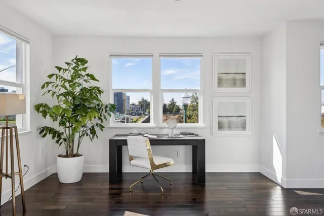 a dining room with furniture potted plants and wooden floor