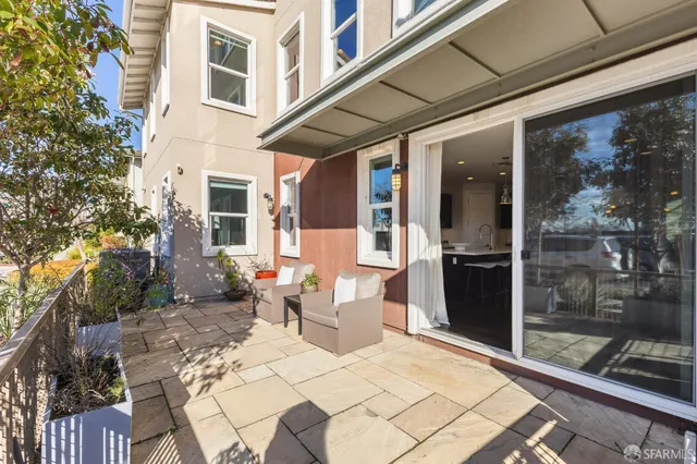 a view of a patio with couches table and chairs and potted plants