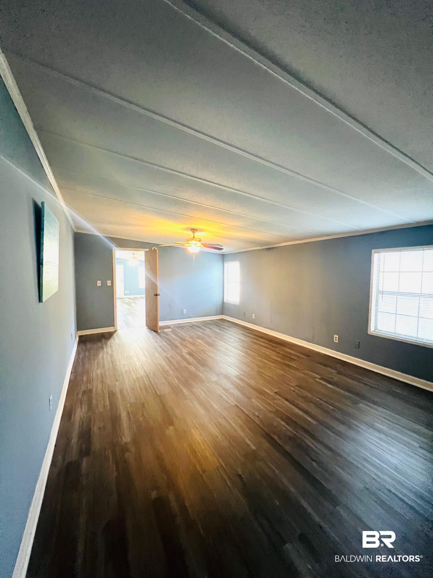 24994 Pompano Drive Elberta, AL 36530 - Photo 10 of 14 Unfurnished room featuring wood finished floors, a ceiling fan, and plenty of natural light