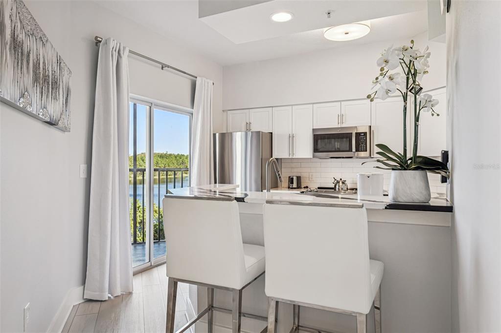 8774 Worldquest Boulevard, Unit 7307 Orlando, FL 32821 - Photo 13 of 52 a kitchen with stainless steel appliances a refrigerator and a stove top oven