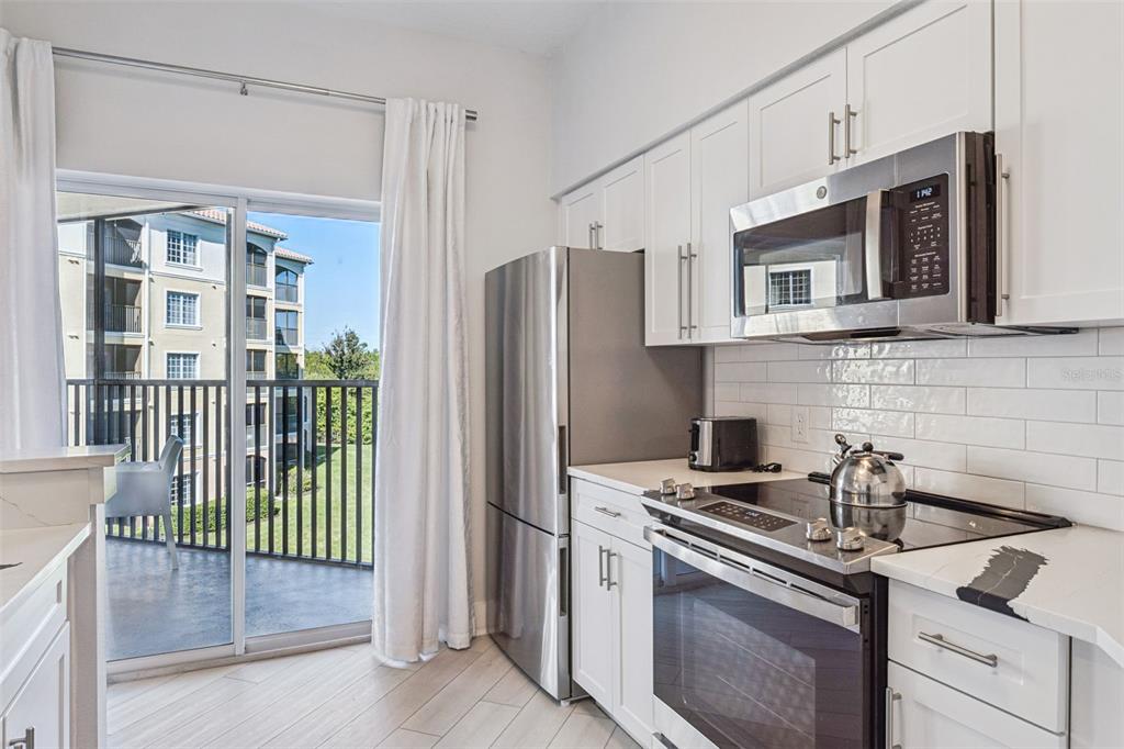 8774 Worldquest Boulevard, Unit 7307 Orlando, FL 32821 - Photo 16 of 52 a kitchen with stainless steel appliances granite countertop a stove and a refrigerator