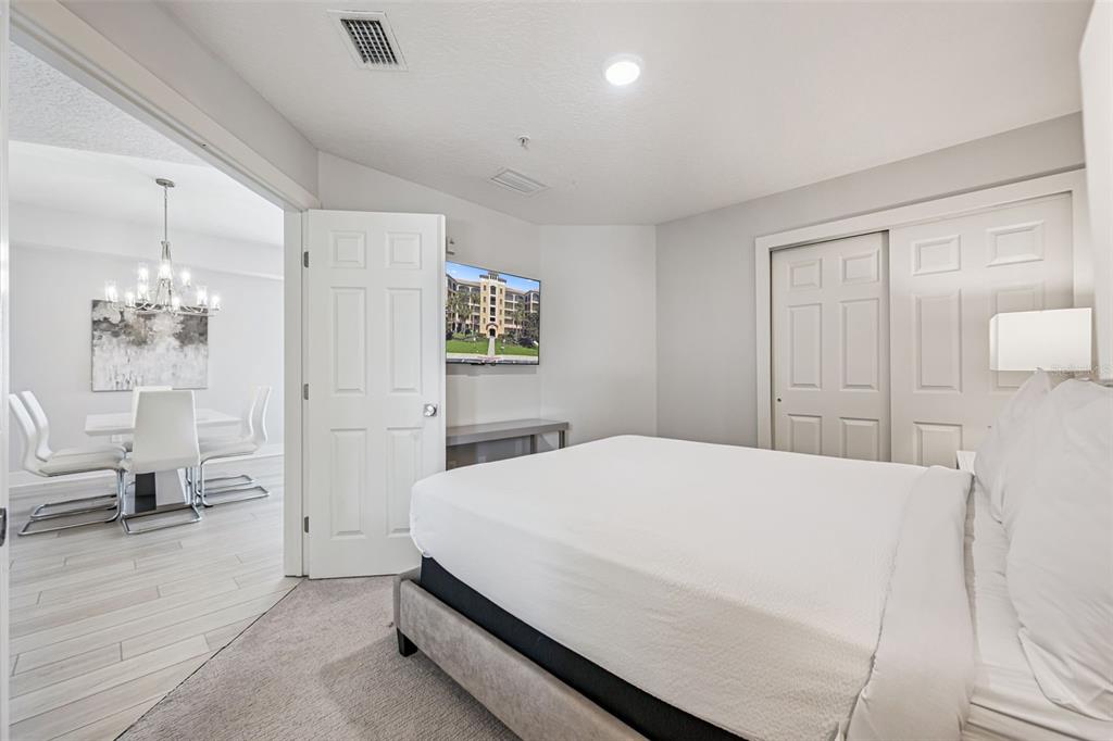 8774 Worldquest Boulevard, Unit 7307 Orlando, FL 32821 - Photo 17 of 52 a bedroom with a bed and a chandelier