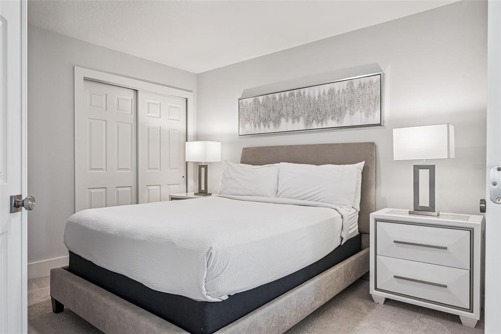 8774 Worldquest Boulevard, Unit 7307 Orlando, FL 32821 - Photo 18 of 52 a bedroom with a bed and a night stand