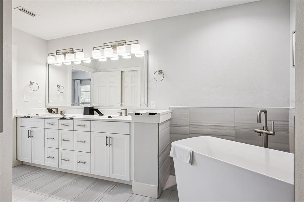 8774 Worldquest Boulevard, Unit 7307 Orlando, FL 32821 - Photo 21 of 52 a bathroom with a double vanity sink and a mirror