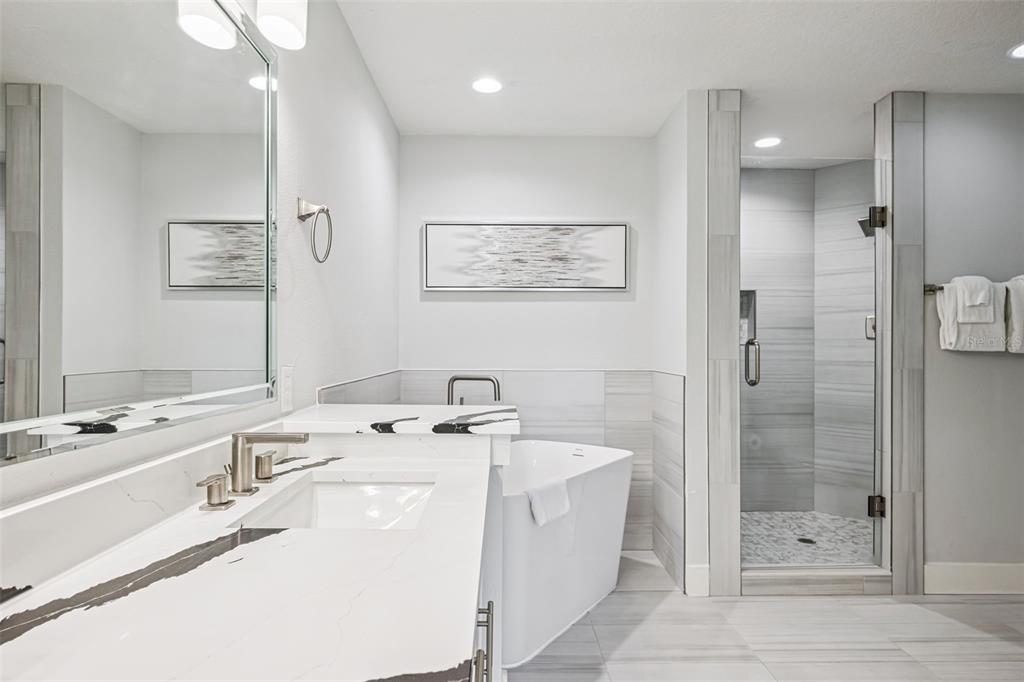 8774 Worldquest Boulevard, Unit 7307 Orlando, FL 32821 - Photo 22 of 52 a bathroom with a tub a sink and mirror