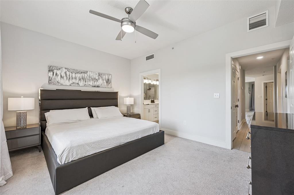 8774 Worldquest Boulevard, Unit 7307 Orlando, FL 32821 - Photo 24 of 52 a bedroom with a large bed and a chandelier
