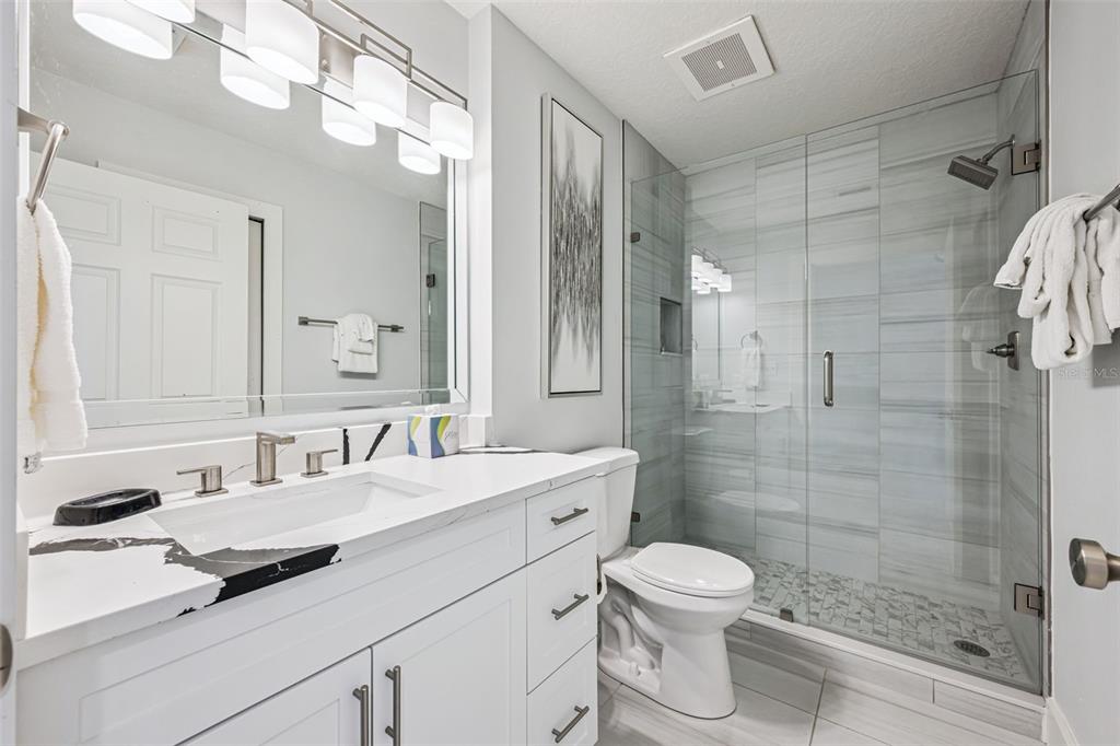 8774 Worldquest Boulevard, Unit 7307 Orlando, FL 32821 - Photo 26 of 52 a bathroom with a sink a toilet and shower