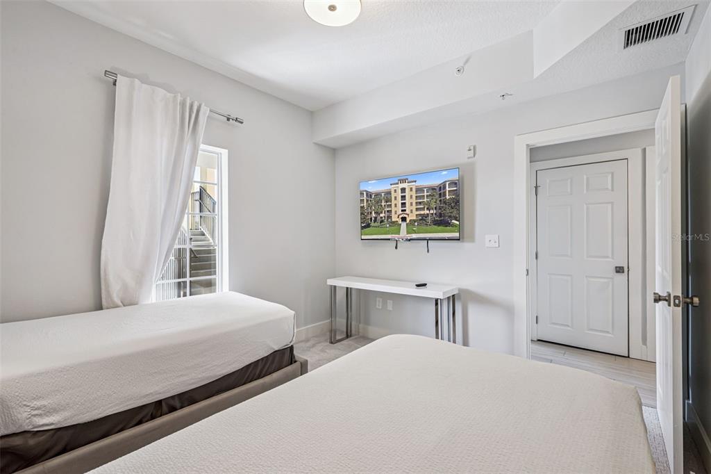 8774 Worldquest Boulevard, Unit 7307 Orlando, FL 32821 - Photo 28 of 52 a bedroom with a bed and a table