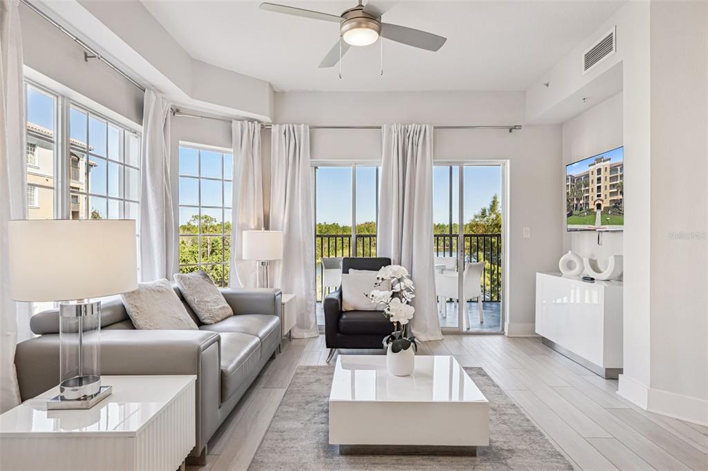 8774 Worldquest Boulevard, Unit 7307 Orlando, FL 32821 - Photo 7 of 52 a living room with furniture and a large window