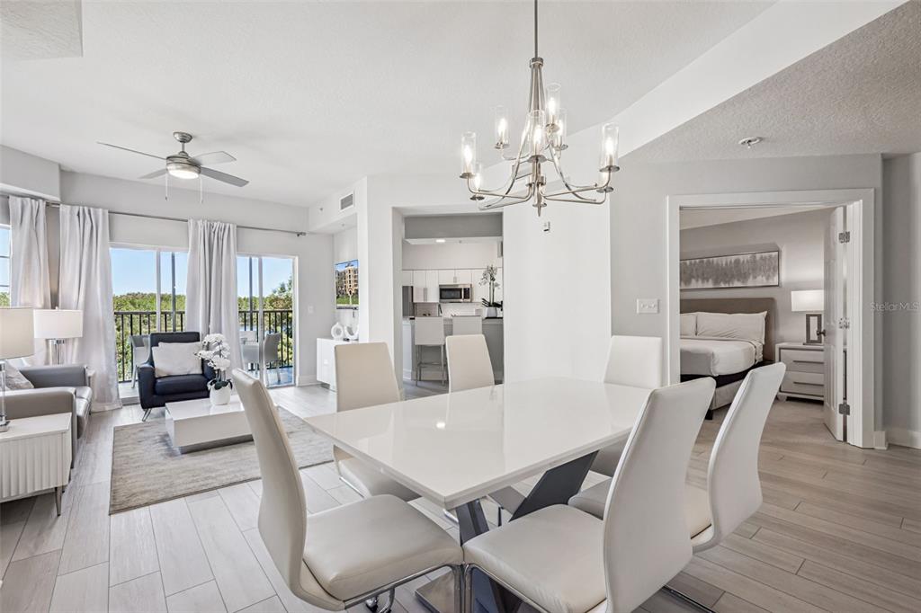 8774 Worldquest Boulevard, Unit 7307 Orlando, FL 32821 - Photo 10 of 52 a view of a dining room with furniture a chandelier and wooden floor