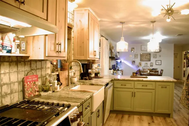 a kitchen with kitchen island granite countertop a sink stove and cabinets