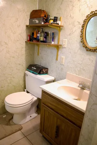 a bathroom with a sink a toilet and a mirror