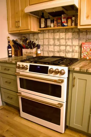 a stove top oven sitting inside of a kitchen