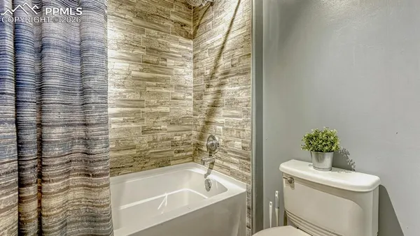 a bathroom with a toilet and a shower curtain