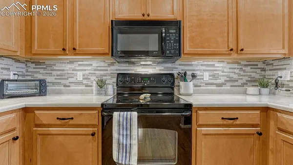 a kitchen with granite countertop white cabinets and black appliances