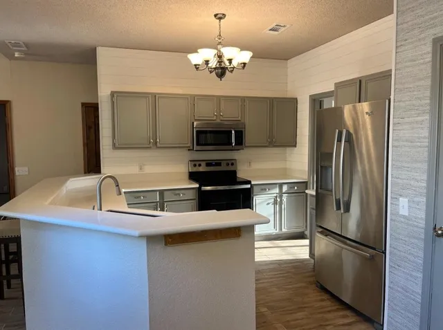 a kitchen with granite countertop a refrigerator oven a sink and dishwasher