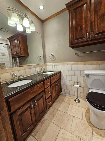 a bathroom with a granite countertop toilet sink and mirror