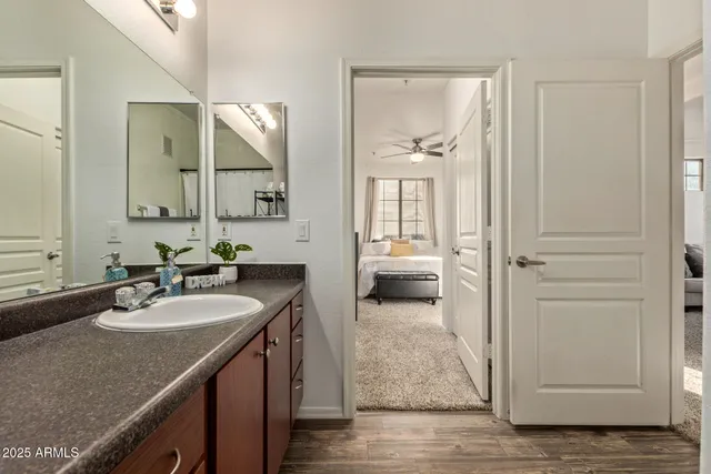 a en suite bathroom with a granite countertop sink and a mirror