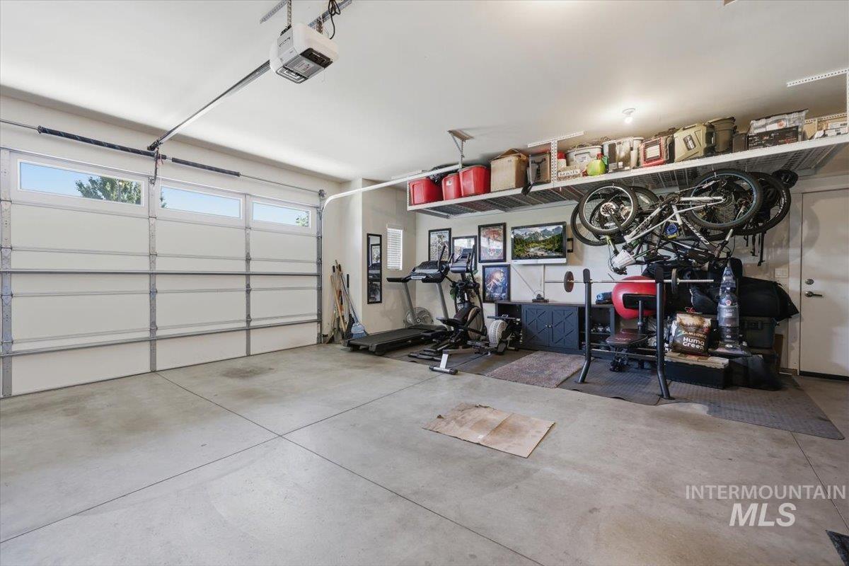 1303 West Brando Street Meridian, ID 83646 - Photo 33 of 49 Spacious garage featuring a concrete floor, an overhead garage door with upper-level windows, and built-in overhead storage shelving