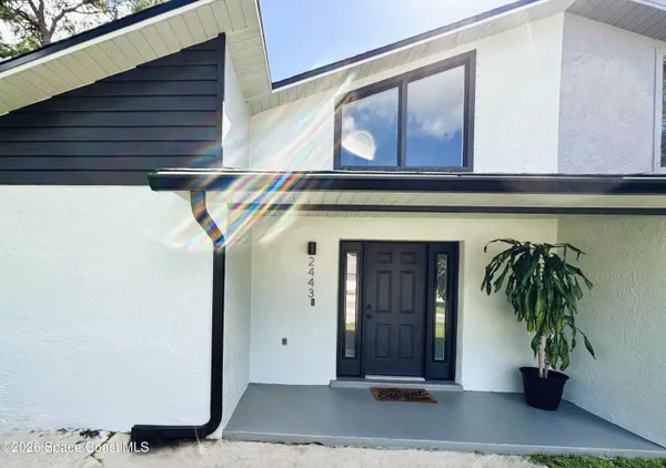 a couple of potted plants in front of door