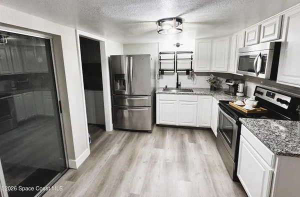 a kitchen with a sink stainless steel appliances and white cabinets