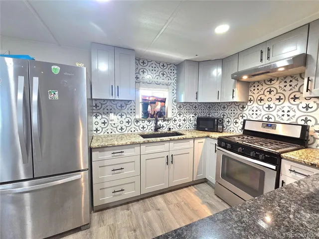 a kitchen with white cabinets and stainless steel appliances