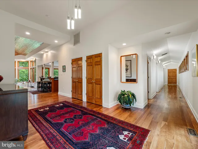 a living room with furniture a rug potted plant and a large window