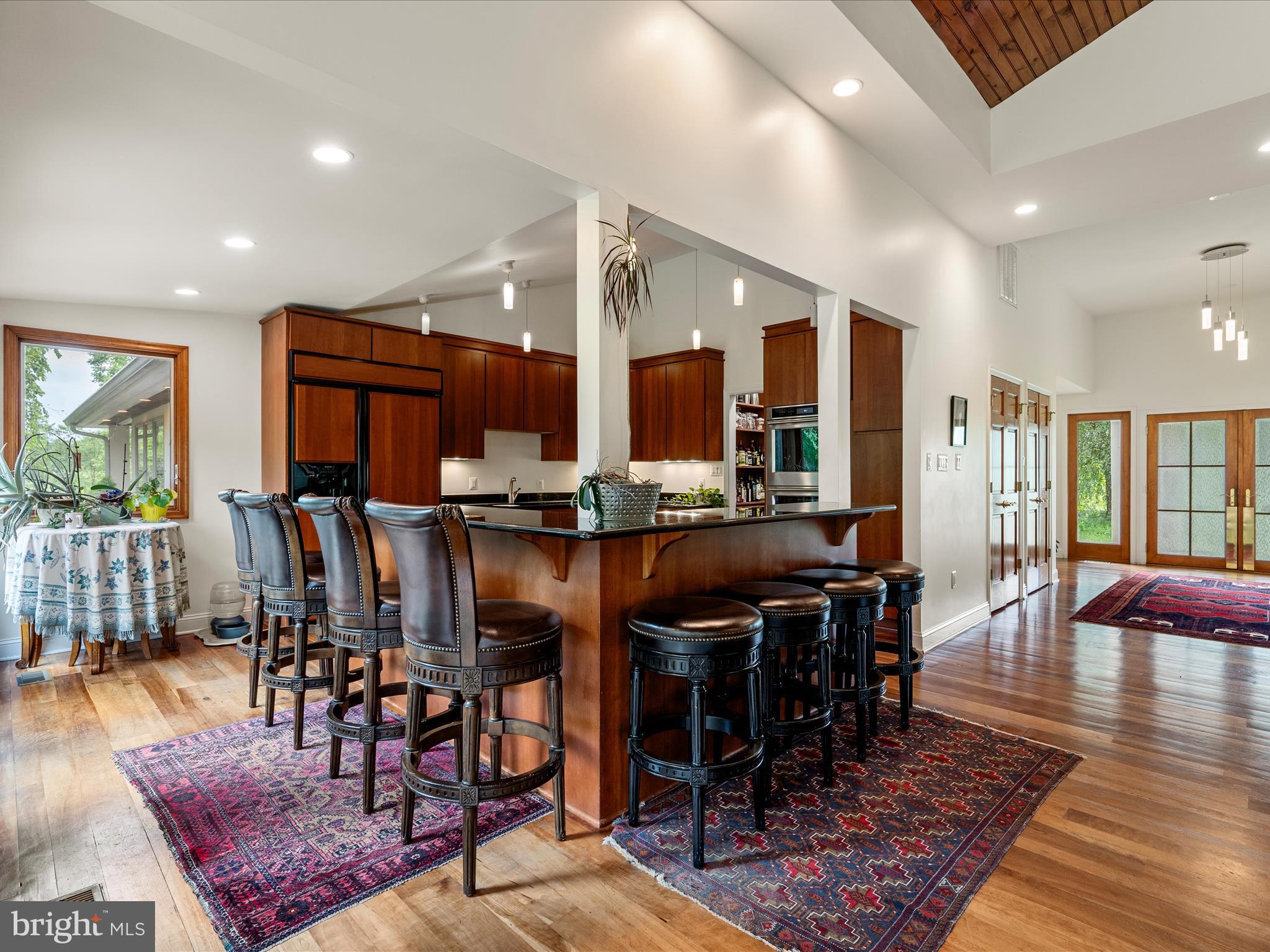 3959 Cobbler Mountain Road Delaplane, VA 20144 - Photo 29 of 106 a kitchen with stainless steel appliances granite countertop a table chairs and a view of living room